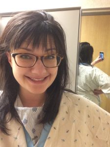 Image of Kelsey Roseth, woman taking selfie with medical gown on prior to MRI